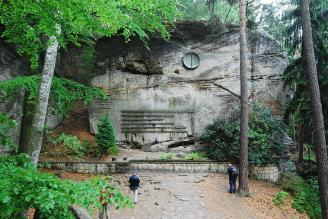 Symbolický hřbitov horolezců ve skalním městě v Hrubé Skále s reliéfem Puklé slunce